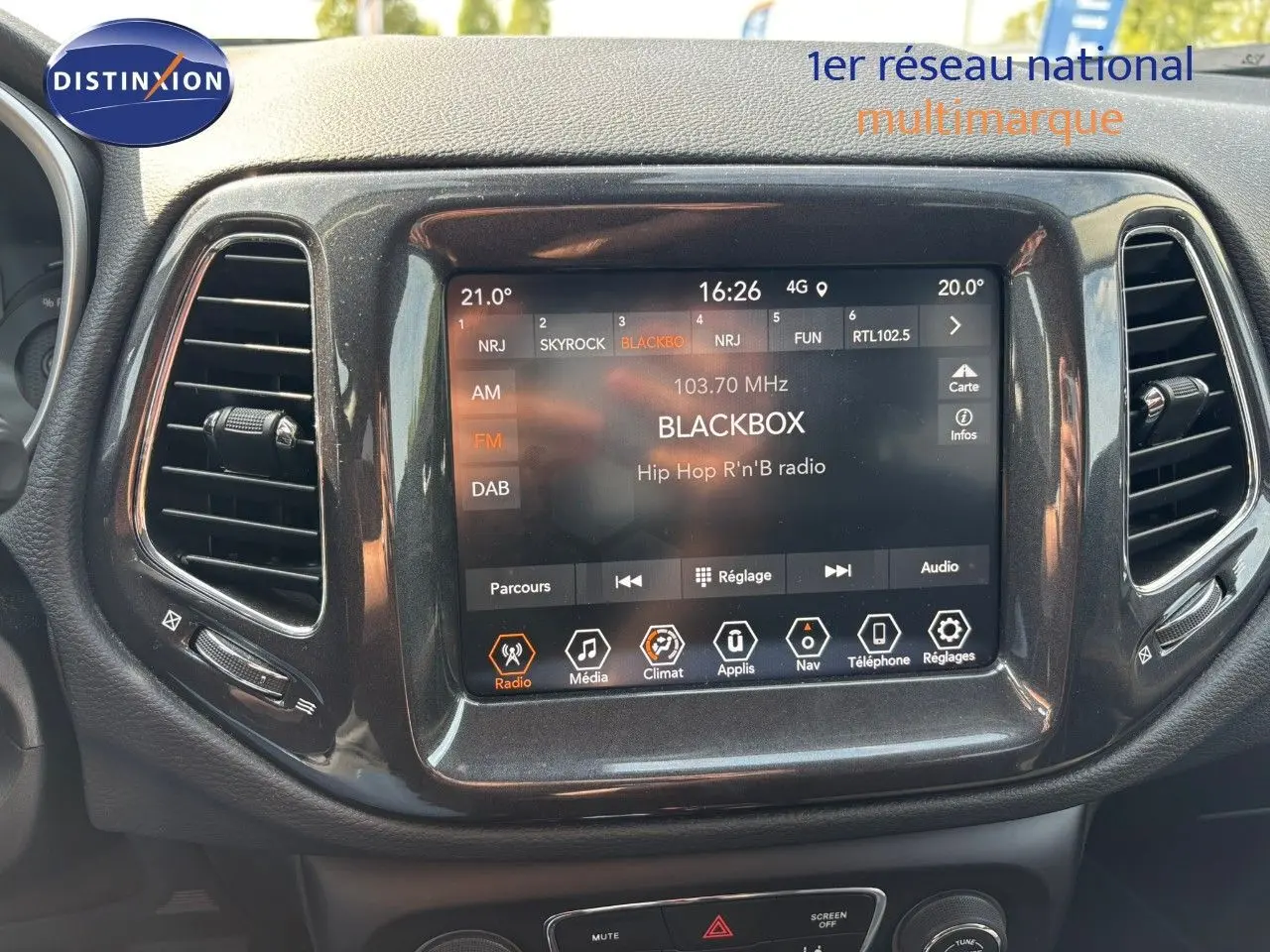 Écran tactile central du tableau de bord du Jeep Compass blanc 2021 affichant une radio Hip Hop R'n'B.