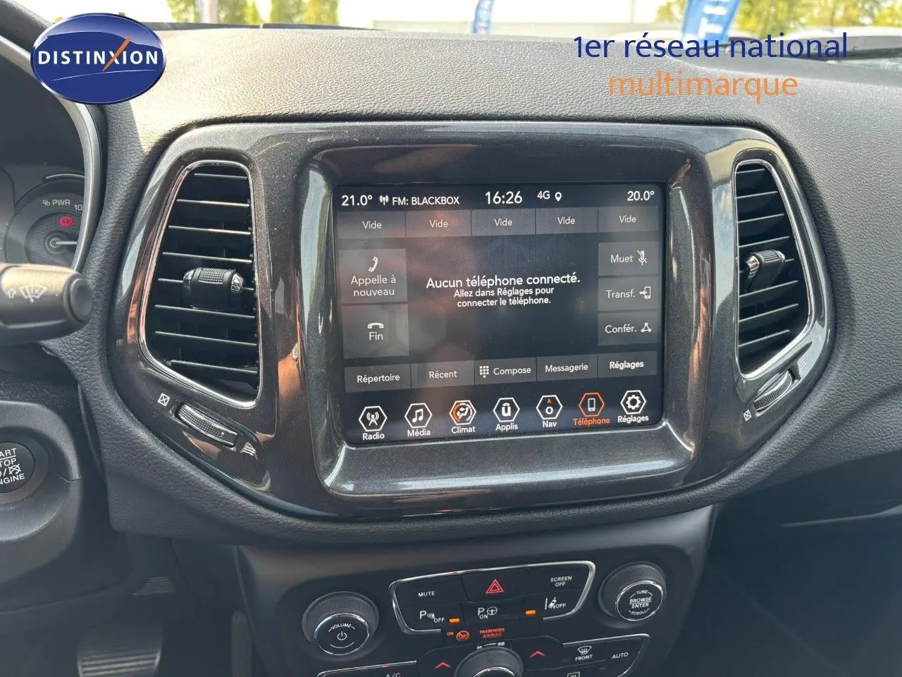 Écran tactile central du tableau de bord du Jeep Compass blanc, affichant le menu téléphone et climatisation.
