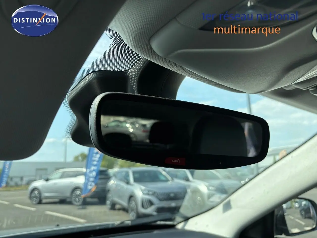 Rétroviseur intérieur d'un Jeep Compass blanc 2021, vue depuis l'habitacle avec reflet du parking extérieur.