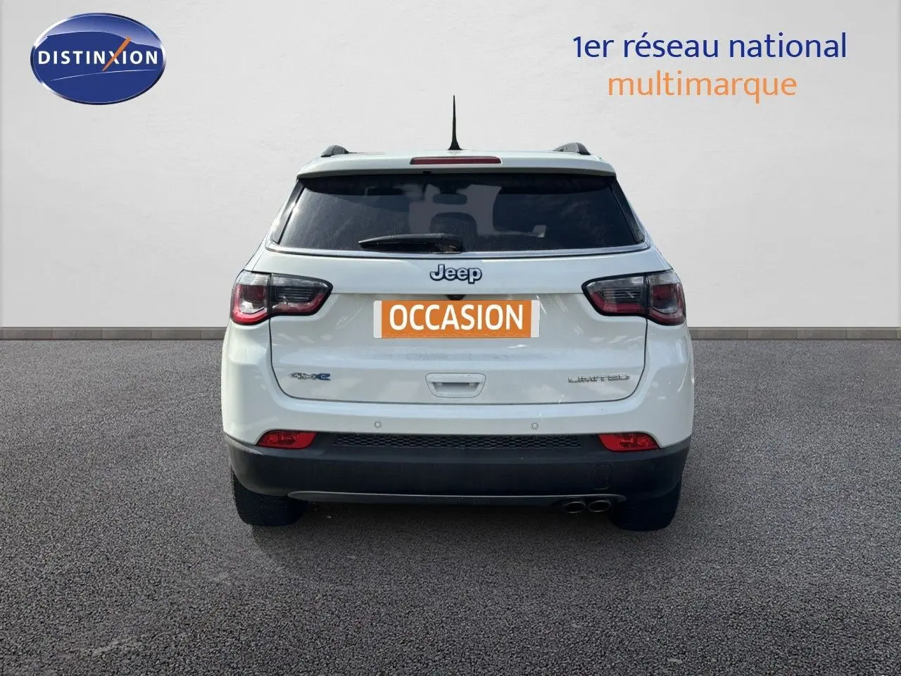 Vue arrière d'un Jeep Compass blanc hybride rechargeable avec badge Limited et double sortie d'échappement.