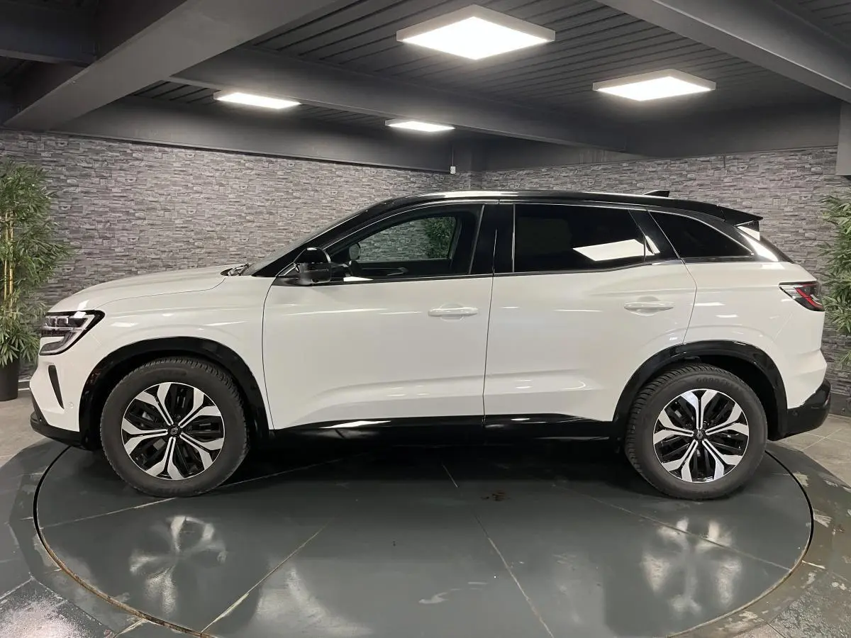 Profil côté gauche du Renault Austral blanc nacré avec toit noir étoilé et jantes alliage 18'' altao diamantées noir.