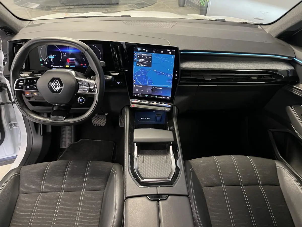 Intérieur du Renault Austral 2024, vue frontale du tableau de bord avec écran tactile vertical et volant multifonction.