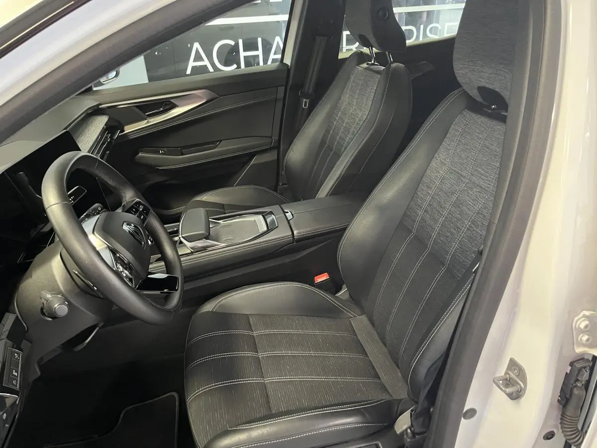 Intérieur noir et gris du Renault Austral 2024, vue côté conducteur avec sièges en simili-cuir et volant textile.