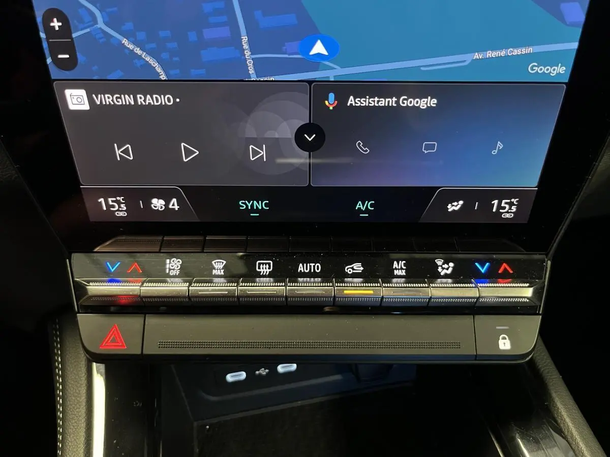 Gros plan sur la console centrale du Renault Austral blanc, affichant l'écran tactile et les commandes de climatisation.