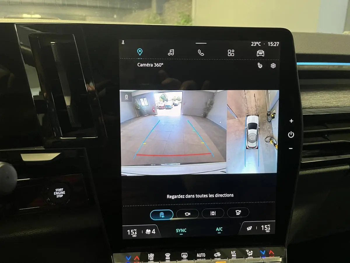 Écran central du Renault Austral blanc montrant la caméra 360° en vue arrière et vue plongeante du parking.