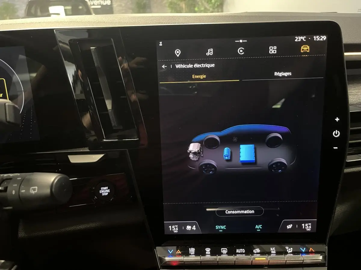 Écran tactile central du tableau de bord du Renault Austral blanc 2024 affichant l'énergie hybride.