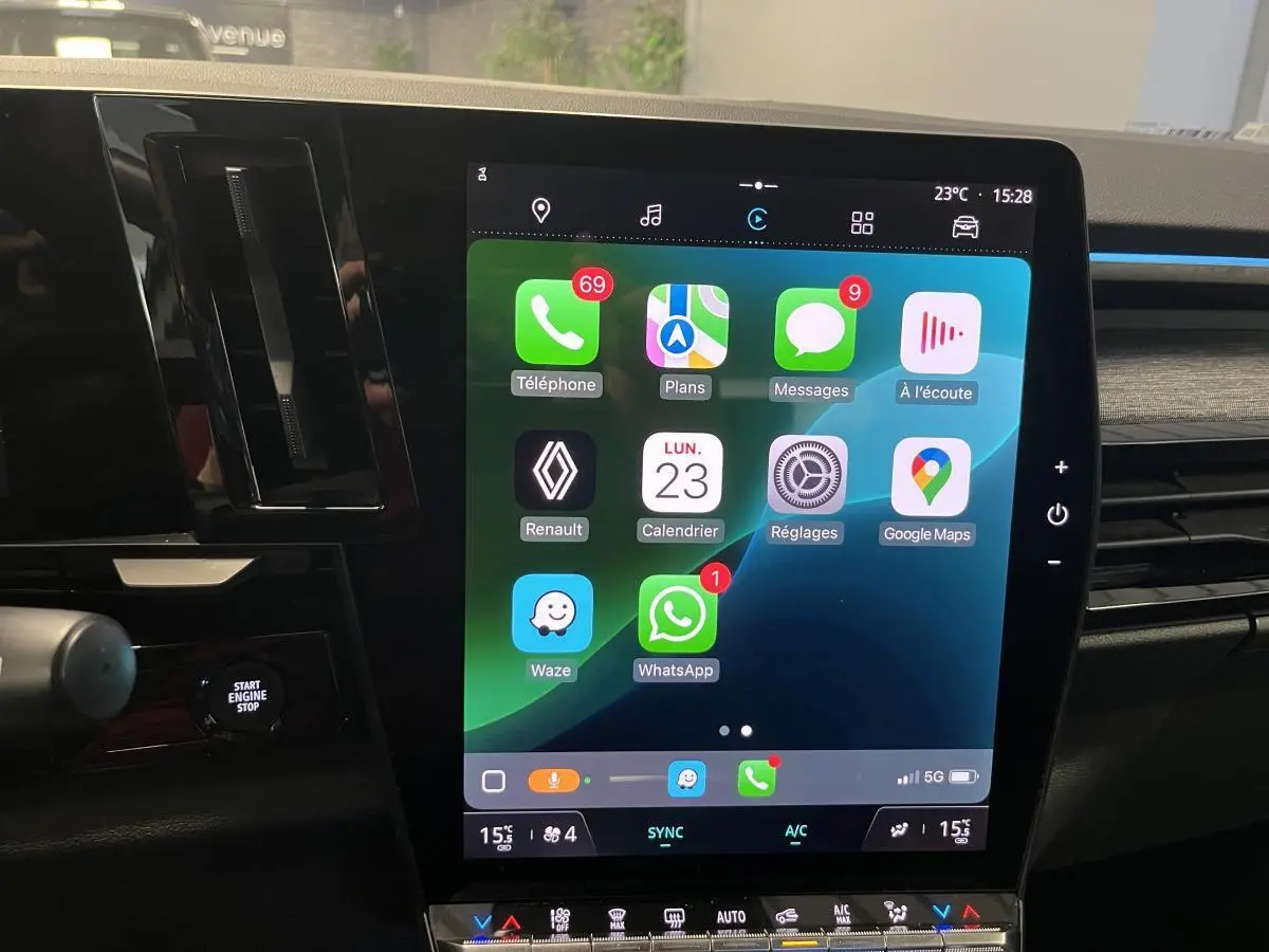 Écran tactile vertical du système multimédia Open R Link dans un Renault Austral blanc, vue intérieure frontale.