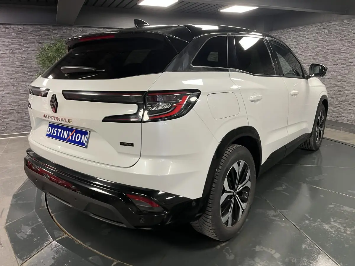 Vue 3/4 arrière droite du Renault Austral blanc nacré avec toit noir étoilé et jantes alliage 18'' noires diamantées.