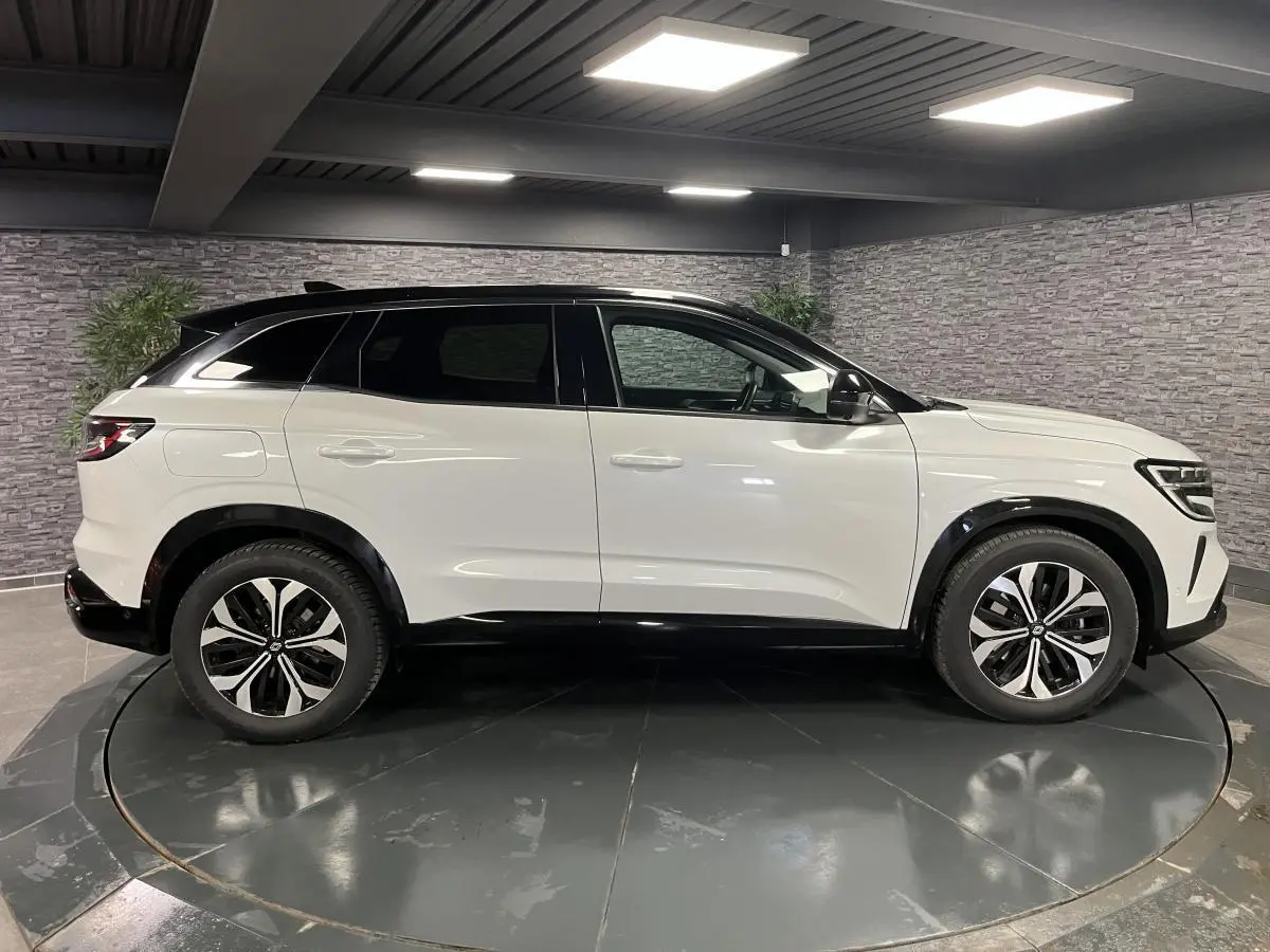 Profil droit du Renault Austral blanc nacré 2024 avec toit noir étoilé et jantes alliage 18'' altao diamantées noir.