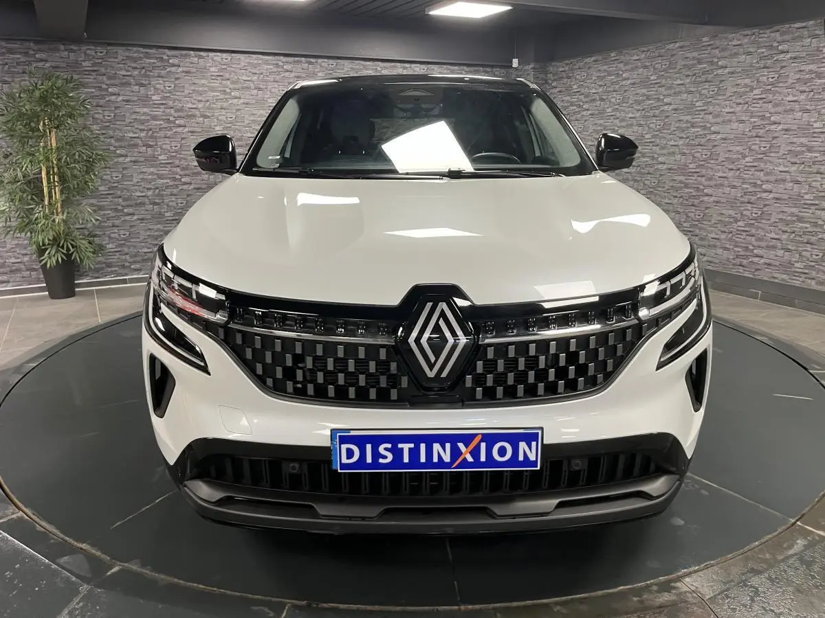 Vue frontale du Renault Austral blanc nacré 2024 avec calandre damier noire et logo Renault proéminent.