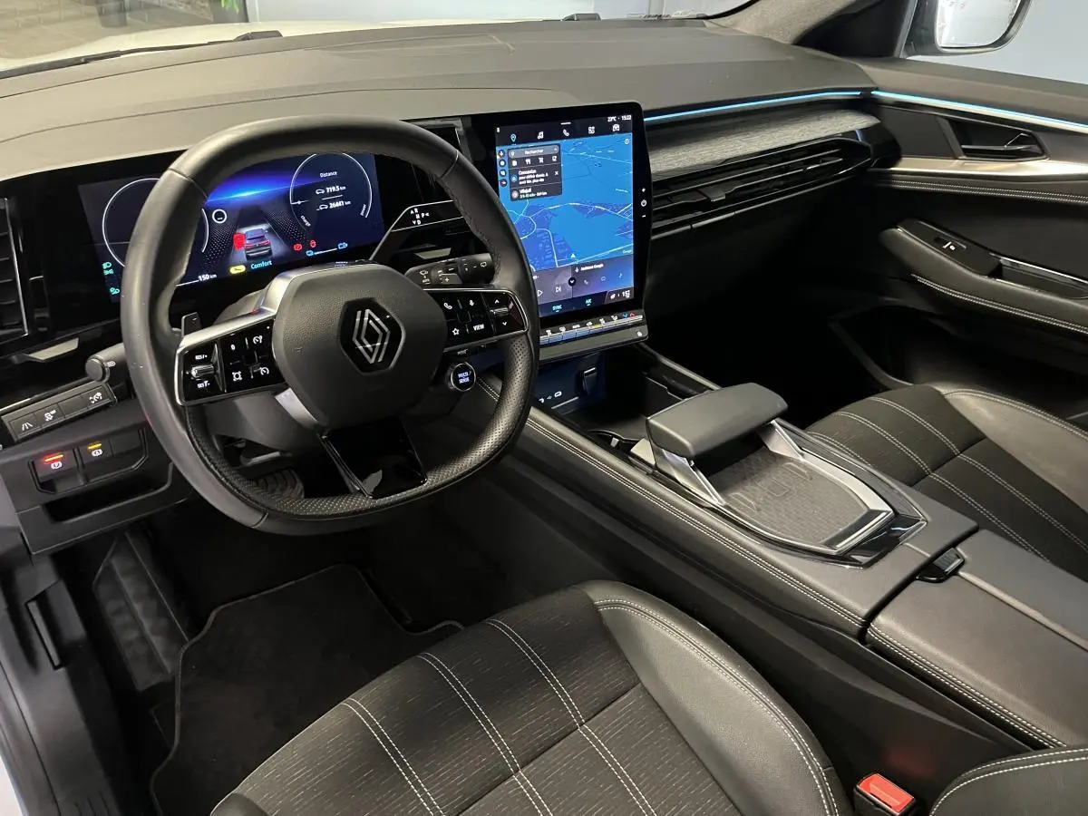 Intérieur du Renault Austral 2024 vu côté conducteur, tableau de bord numérique et écran tactile central lumineux.