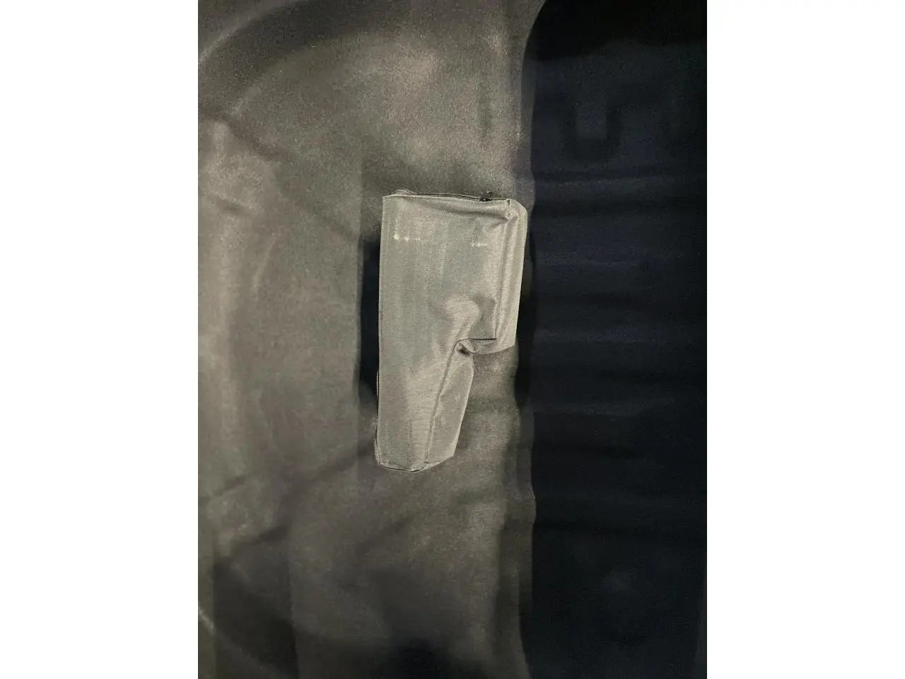 Gros plan sur un rangement en tissu noir dans le coffre d'une Volkswagen Golf 1.5 eTSI Style 2024.