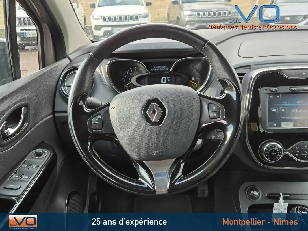 Vue intérieure centrée sur le volant cuir Renault Captur gris 2014 avec tableau de bord et écran tactile visible