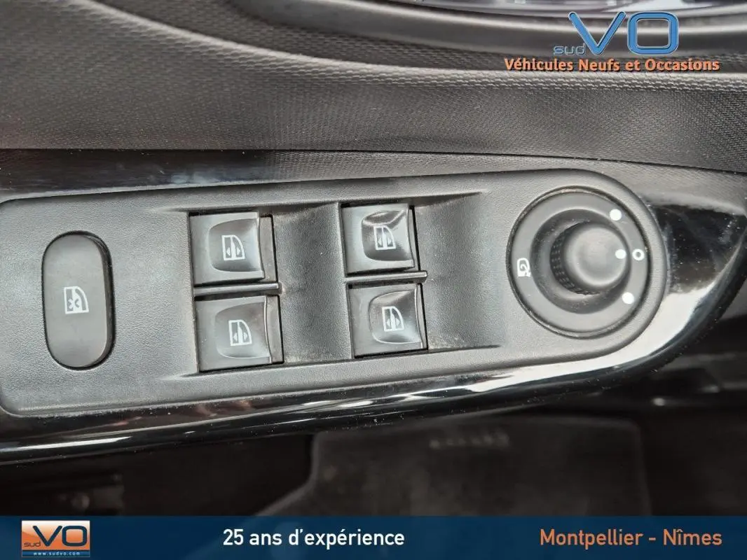 Gros plan sur les commandes électriques des vitres et rétroviseurs du côté gauche d'un Renault Captur gris 2014.