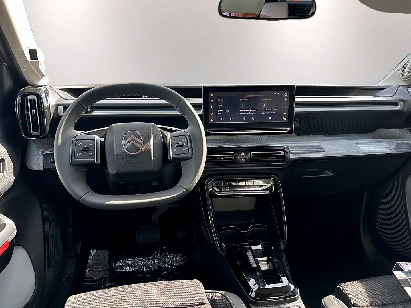 Tableau de bord et volant noir de Citroën C3 Aircross 2026 vus de face avec écran tactile central allumé.