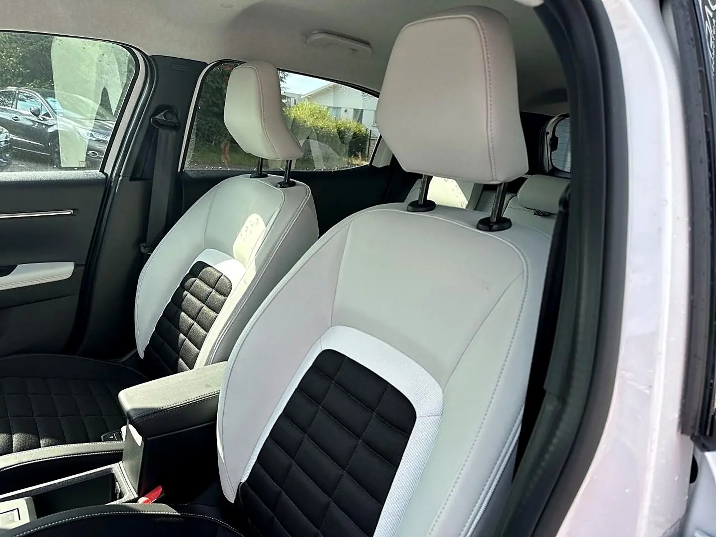 Vue intérieure côté droit des sièges avant bicolores blanc et noir du Citroën C3 Aircross 2026 hybride.