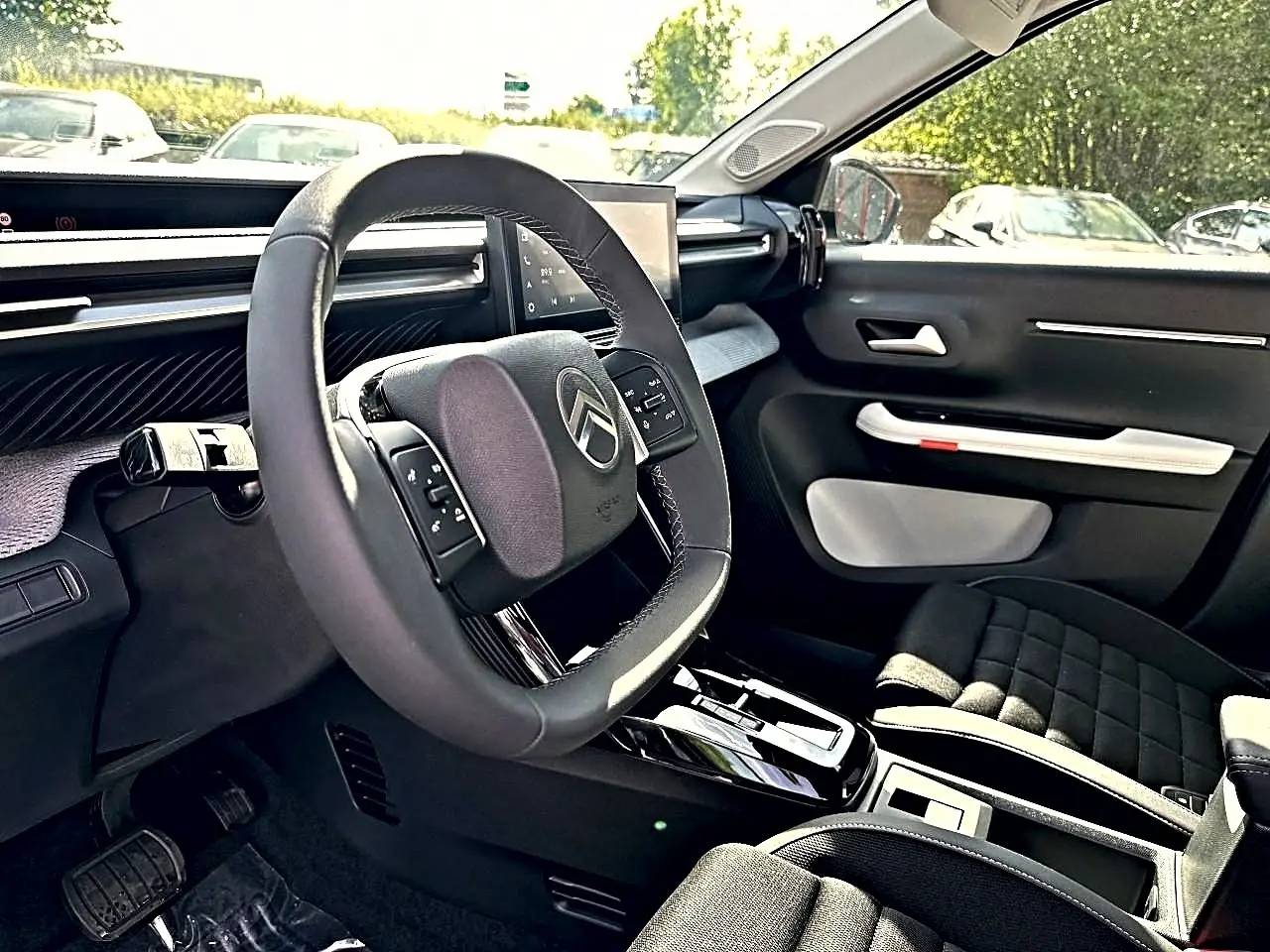 Vue intérieure côté conducteur du Citroën C3 Aircross 2026, volant multifonction et sièges noirs avec console centrale.