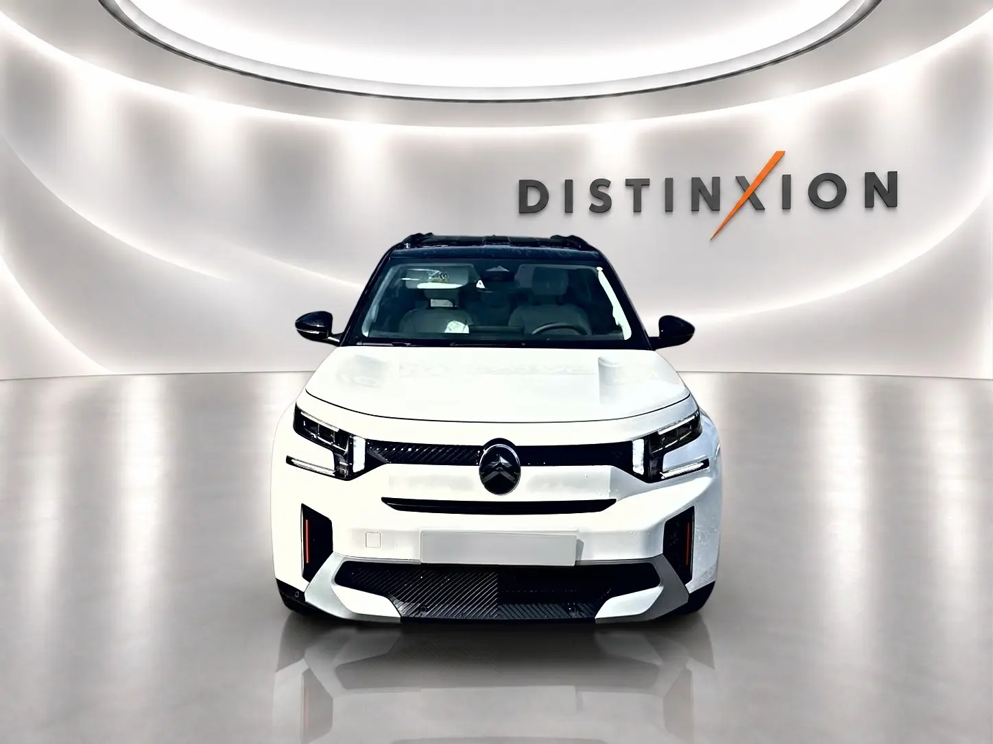 Vue frontale d'un Citroën C3 Aircross blanc avec toit noir, calandre noire et éclairage LED distinctif.