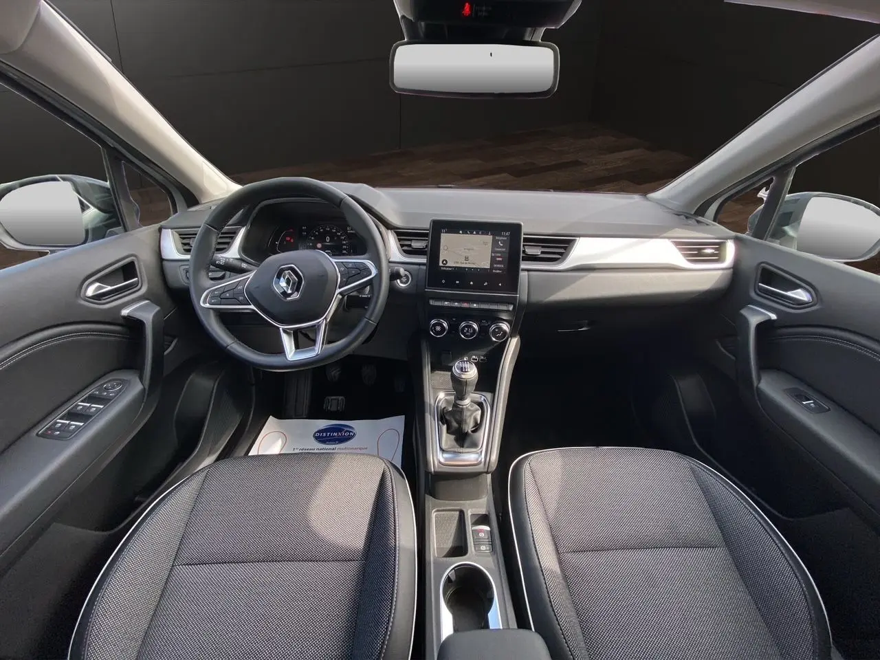 Intérieur noir du Renault Captur TCE 90 Techno 2024, vue frontale du tableau de bord et console centrale avec écran tactile.