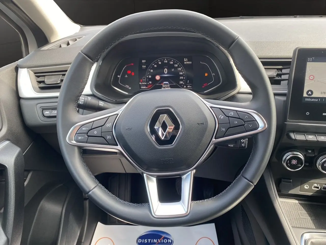 Vue rapprochée du volant noir du Renault Captur TCe 90 Techno 2024 avec tableau de bord numérique et console centrale.