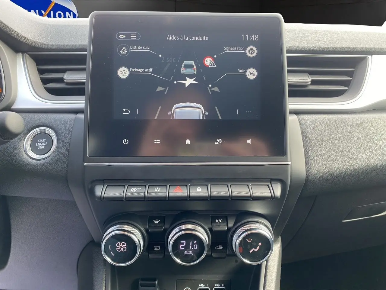 Tableau de bord du Renault Captur TCe 90 Techno 2024, écran tactile affichant aides à la conduite, ambiance intérieure noire.