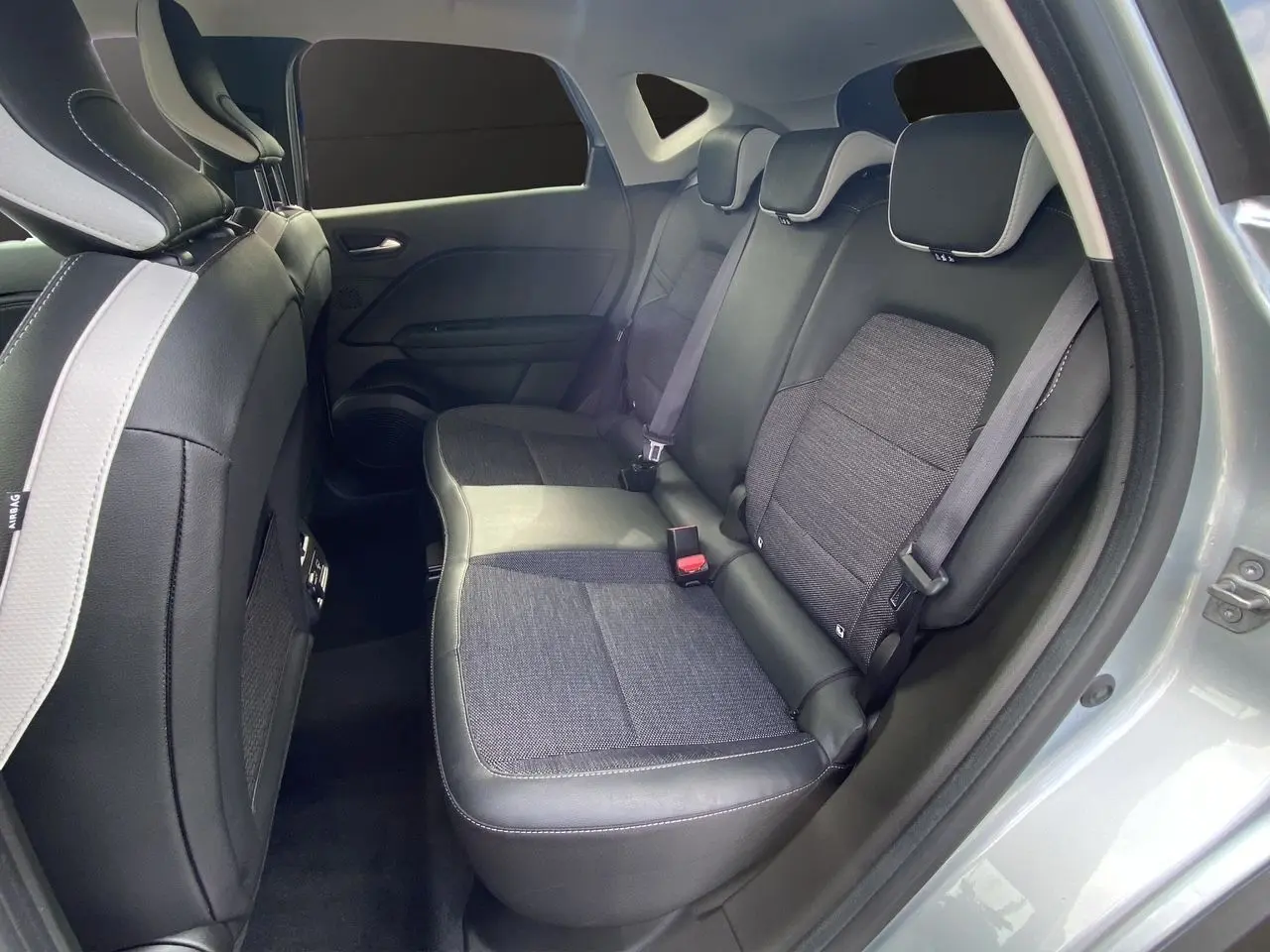 Vue côté droit de la banquette arrière en tissu et cuir noir du Renault Captur TCE 90 TECHNO gris Highland 2024.