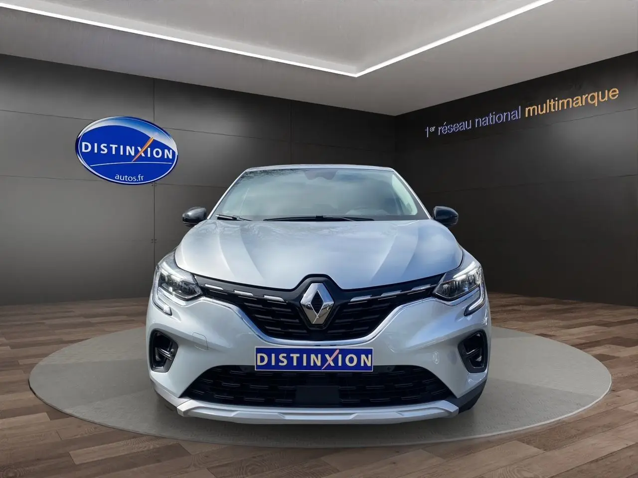 Vue frontale du Renault Captur TCE 90 TECHNO gris Highland, avec calandre noire et logo Renault bien visible.