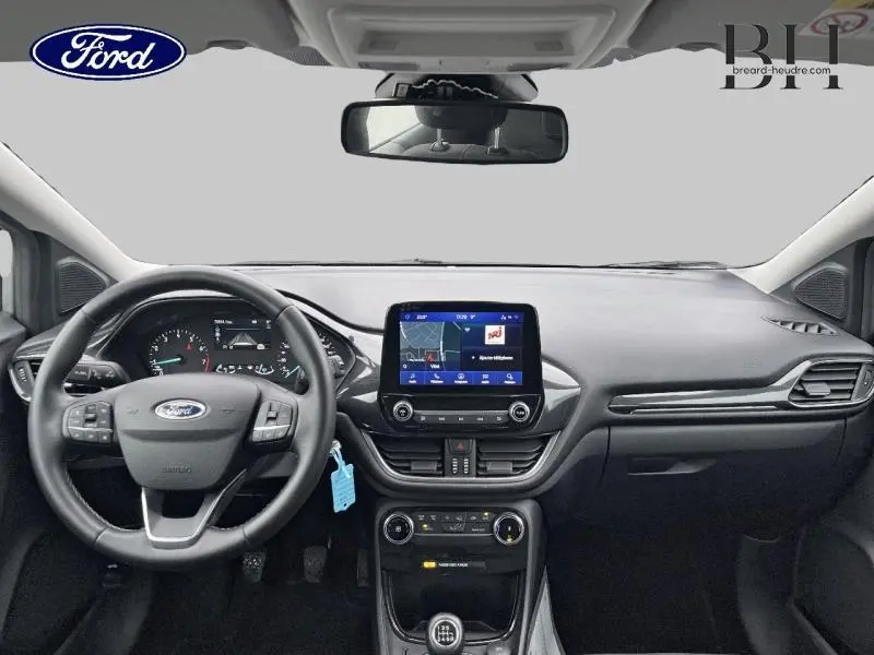 Vue intérieure frontale du tableau de bord du Ford Puma 2023, avec écran tactile central et volant multifonction noir.