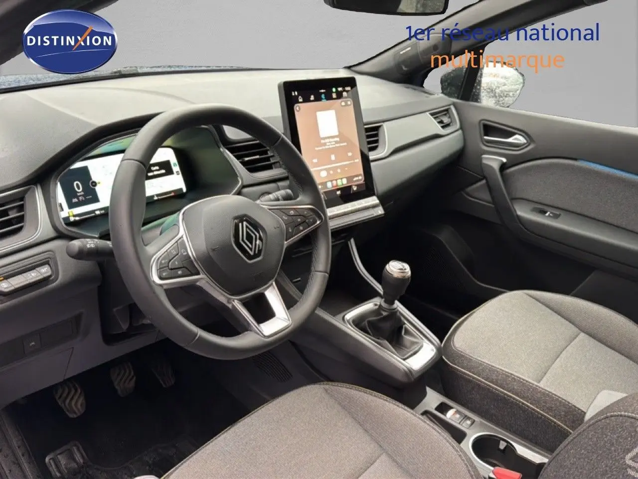 Vue intérieure côté conducteur du Renault Captur 2025, tableau de bord moderne avec écran tactile vertical et volant multifonction noir.