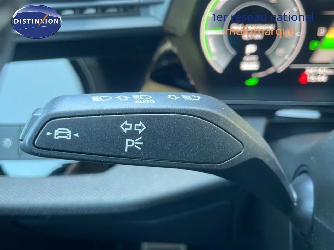 Gros plan sur la commande de clignotant noire dans l’habitacle de l’Audi A3 Sportback 2025, avec tableau de bord numérique en arrière-plan.