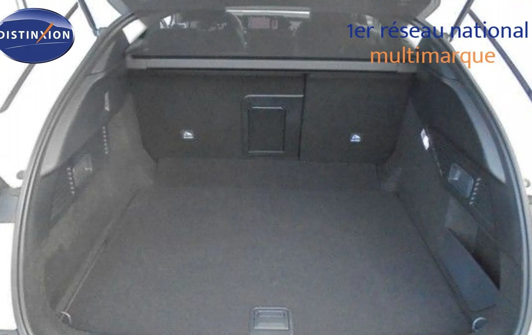 Coffre ouvert d'une Citroën C5 X blanc métal 2023, vue intérieure montrant un espace de chargement spacieux et noir.