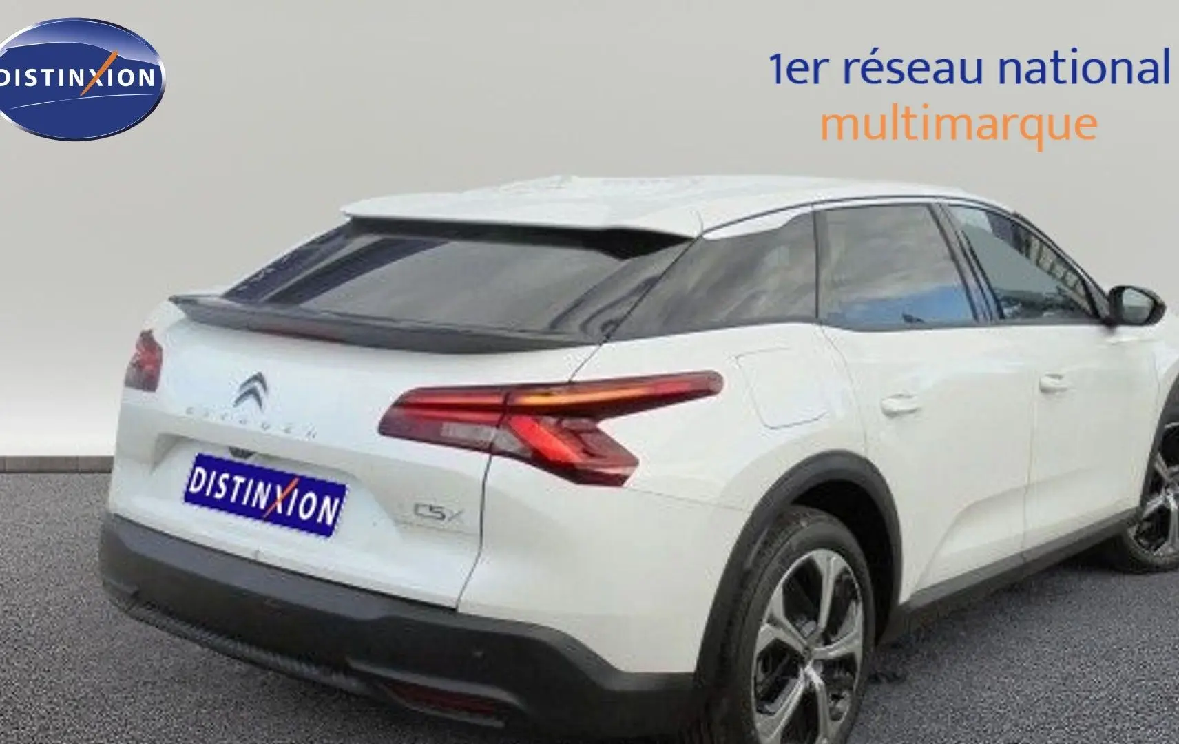 Vue 3/4 arrière droite d'une Citroën C5 X blanche métallisée avec feux arrière LED et jantes bi-ton.