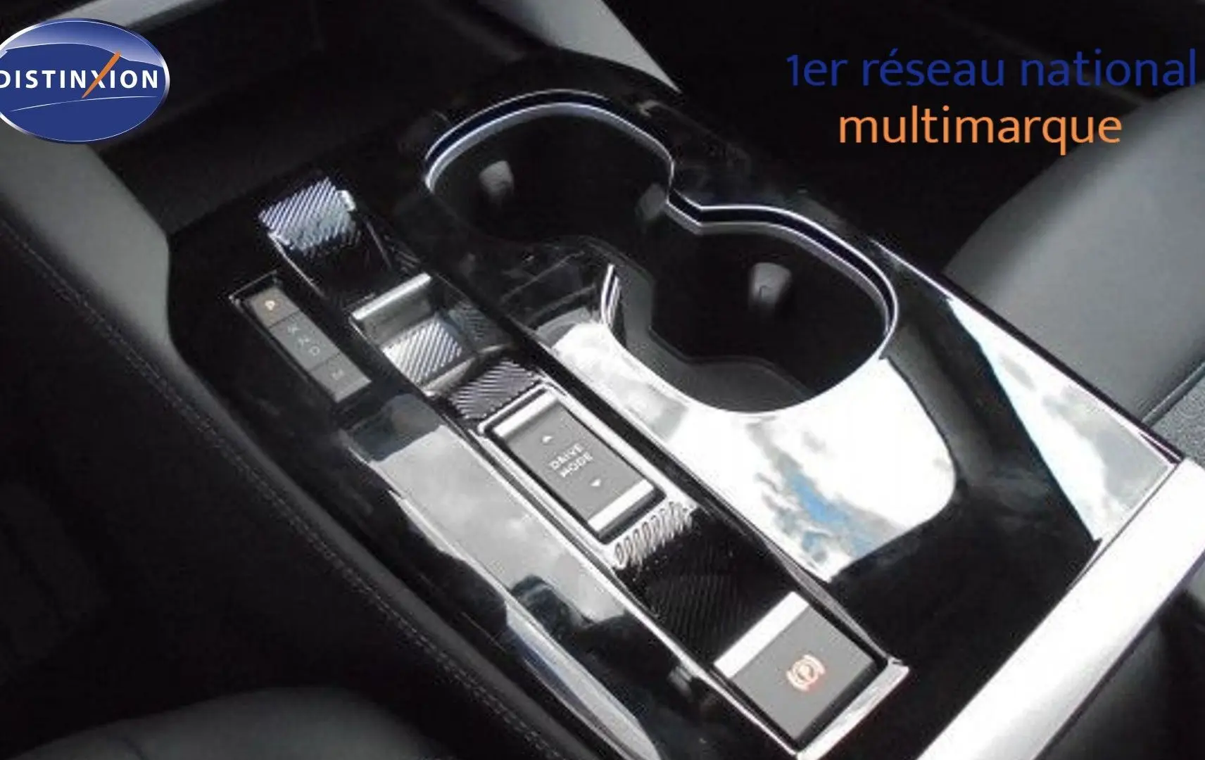 Console centrale noire brillante avec commandes électroniques et porte-gobelets dans l'habitacle d'une Citroën C5 X 2023.