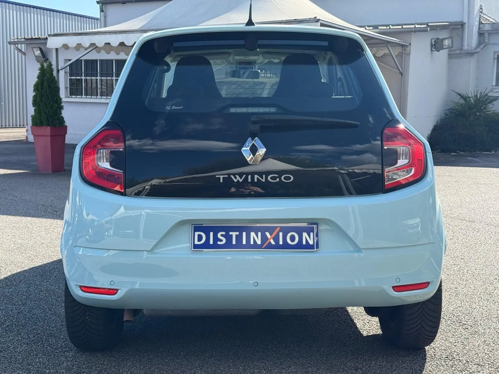 Vue arrière de la Renault Twingo III bleu dragée avec toit noir brillant et feux arrière LED distinctifs.