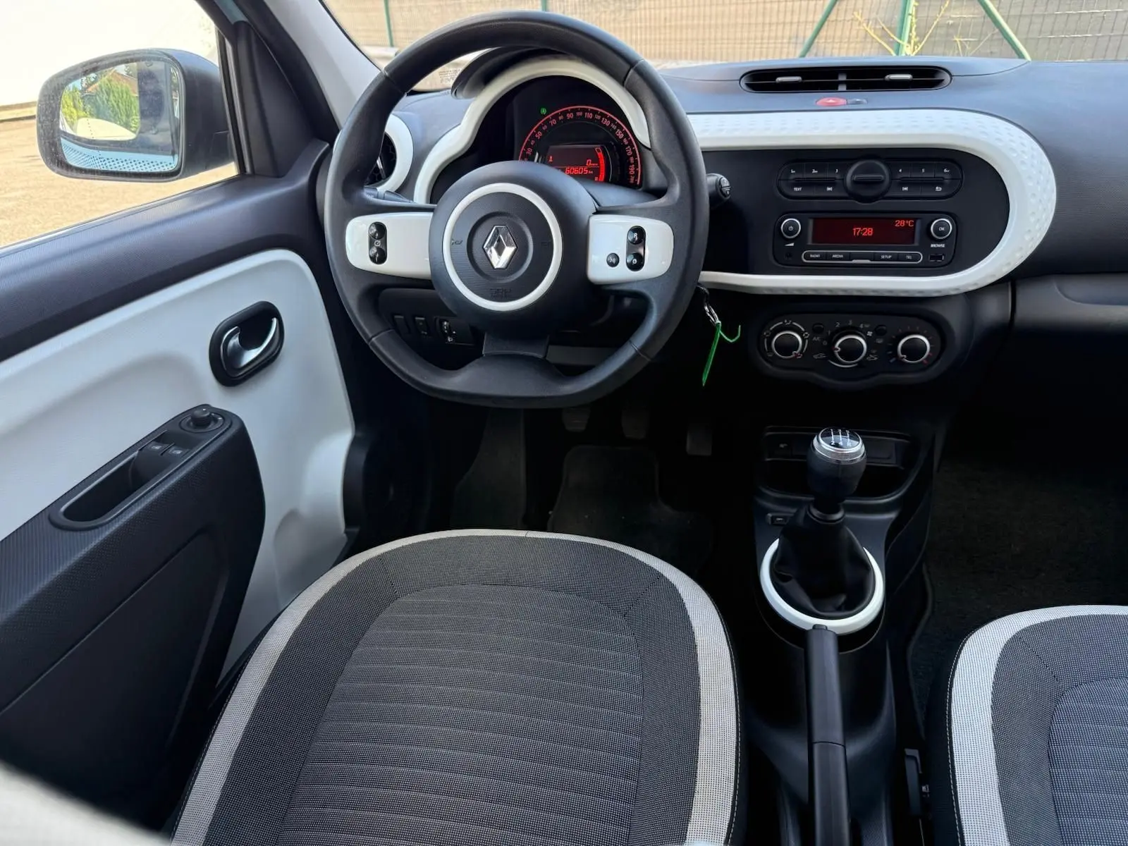 Intérieur de la Renault Twingo III 2021 en bleu dragée, vue de face sur le tableau de bord et la boîte manuelle.