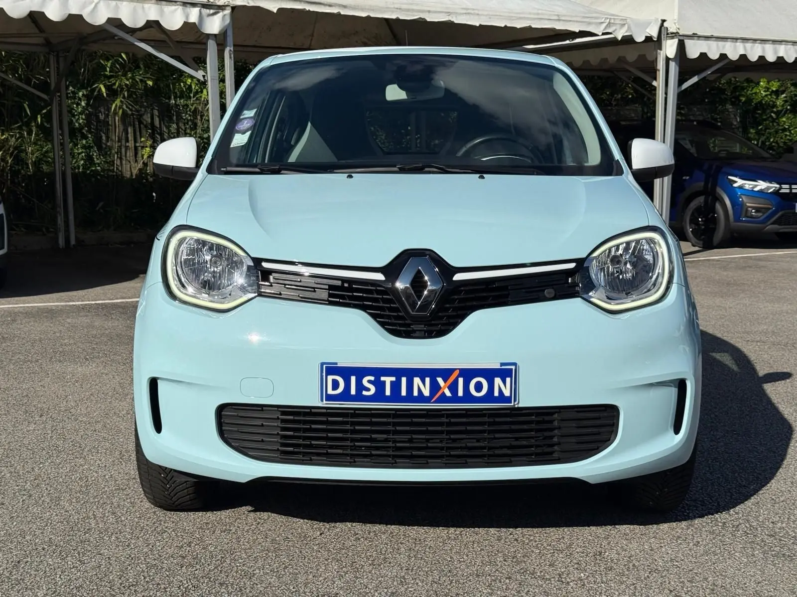 Renault Twingo III bleu dragée vue de face, mettant en valeur ses phares ronds et la calandre noire distinctive.