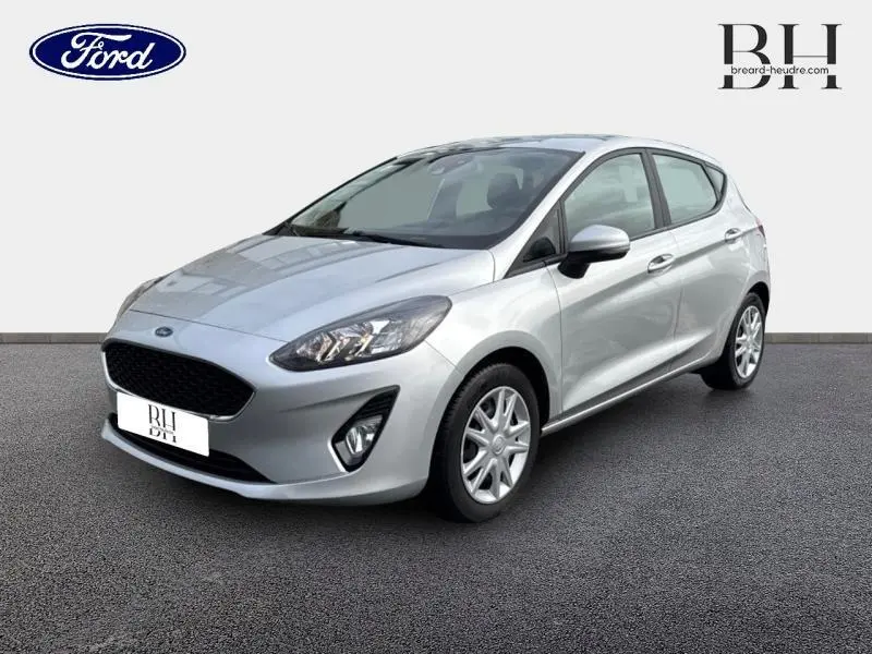 Vue 3/4 avant droite d'une Ford Fiesta gris lunaire 5 portes avec calandre noire et jantes argentées.