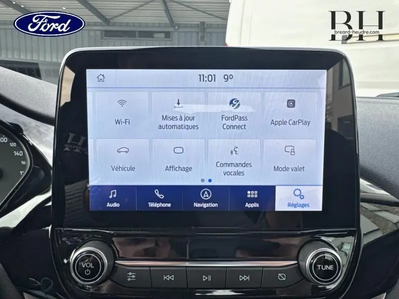 Écran tactile central du tableau de bord de la Ford Fiesta gris lunaire, affichant le menu des réglages connectés.