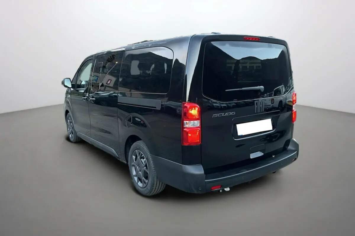 Vue 3/4 arrière droite du FIAT Scudo Fourgon noir avec vitres surteintées et feux arrière allumés.