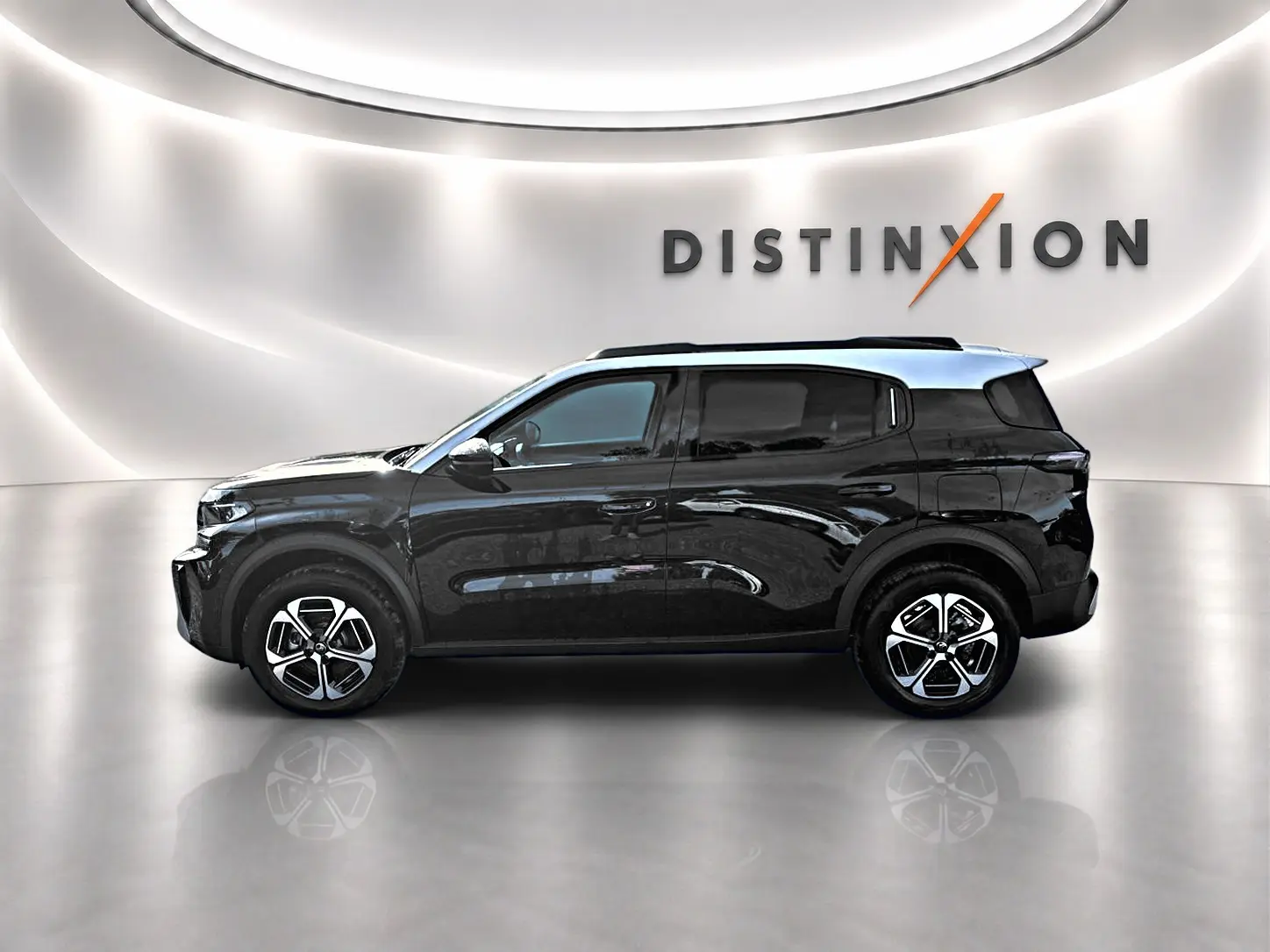 Profil droit d'un Citroën C3 Aircross noir 2026 avec jantes alu et barres de toit, sur fond lumineux avec logo Distinxion.