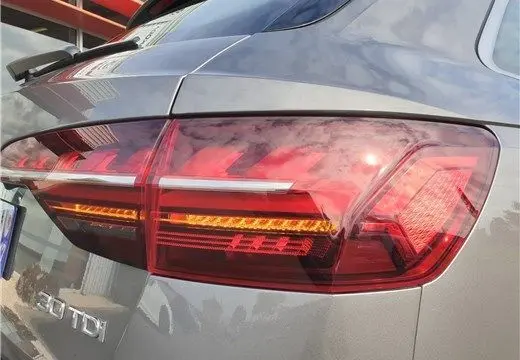 Gros plan sur le feu arrière droit rouge et orange d'une Audi A4 Avant Business 30 TDI gris Terra de 2020.