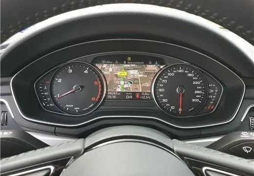 Vue rapprochée du tableau de bord numérique de l'Audi A4 Avant Business 2020, affichant la navigation et les compteurs.