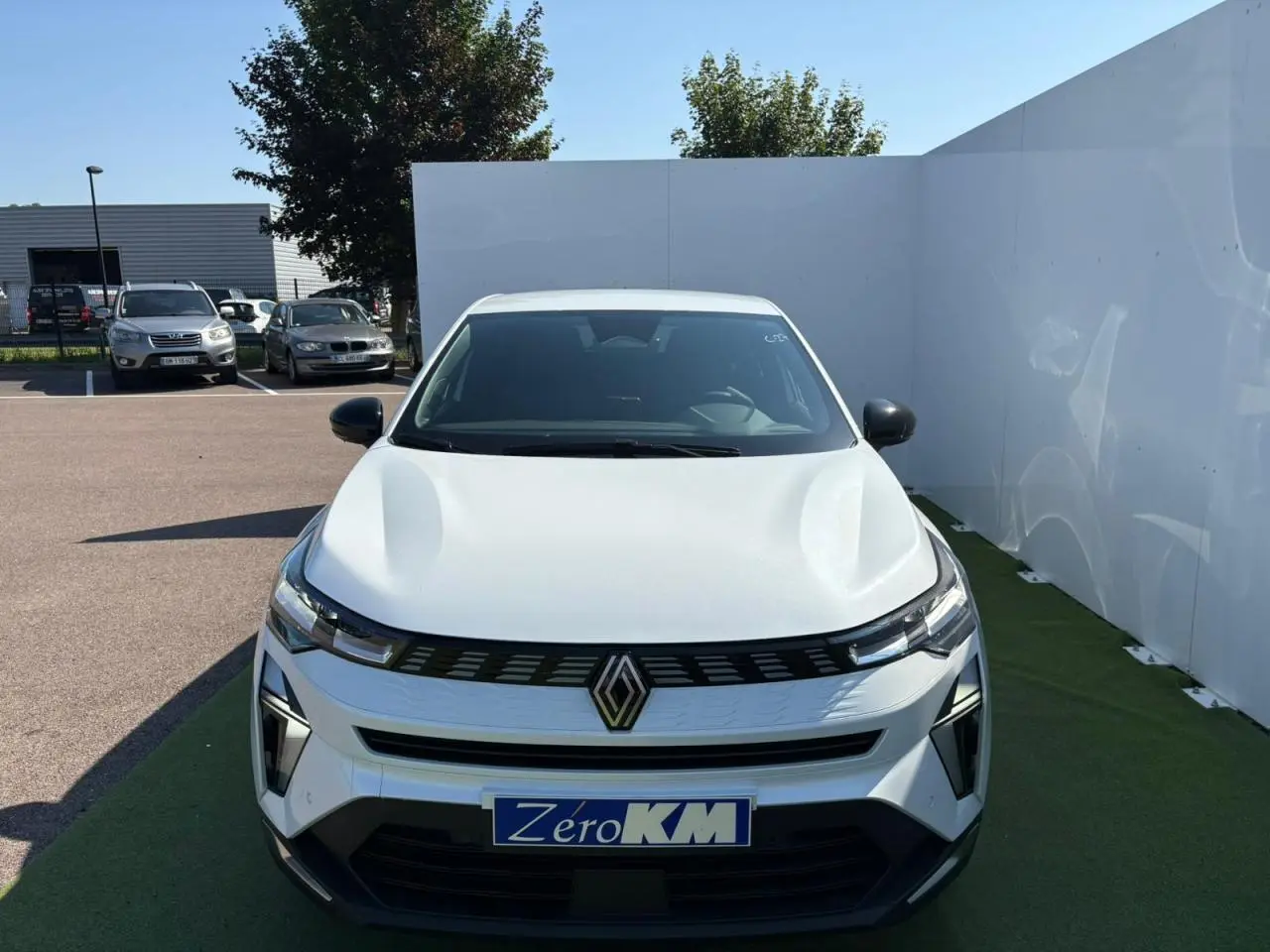 Vue frontale d'une Renault Symbioz blanc nacré avec calandre noire et logo Renault bien visible.
