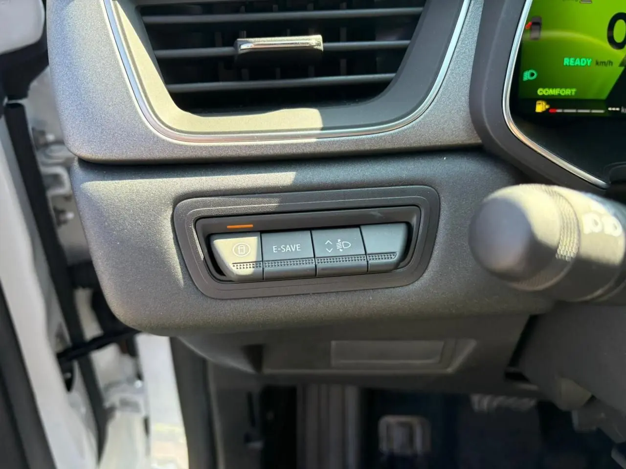 Gros plan sur les commandes sous la ventilation côté gauche du tableau de bord du Renault Symbioz blanc nacré 2025.