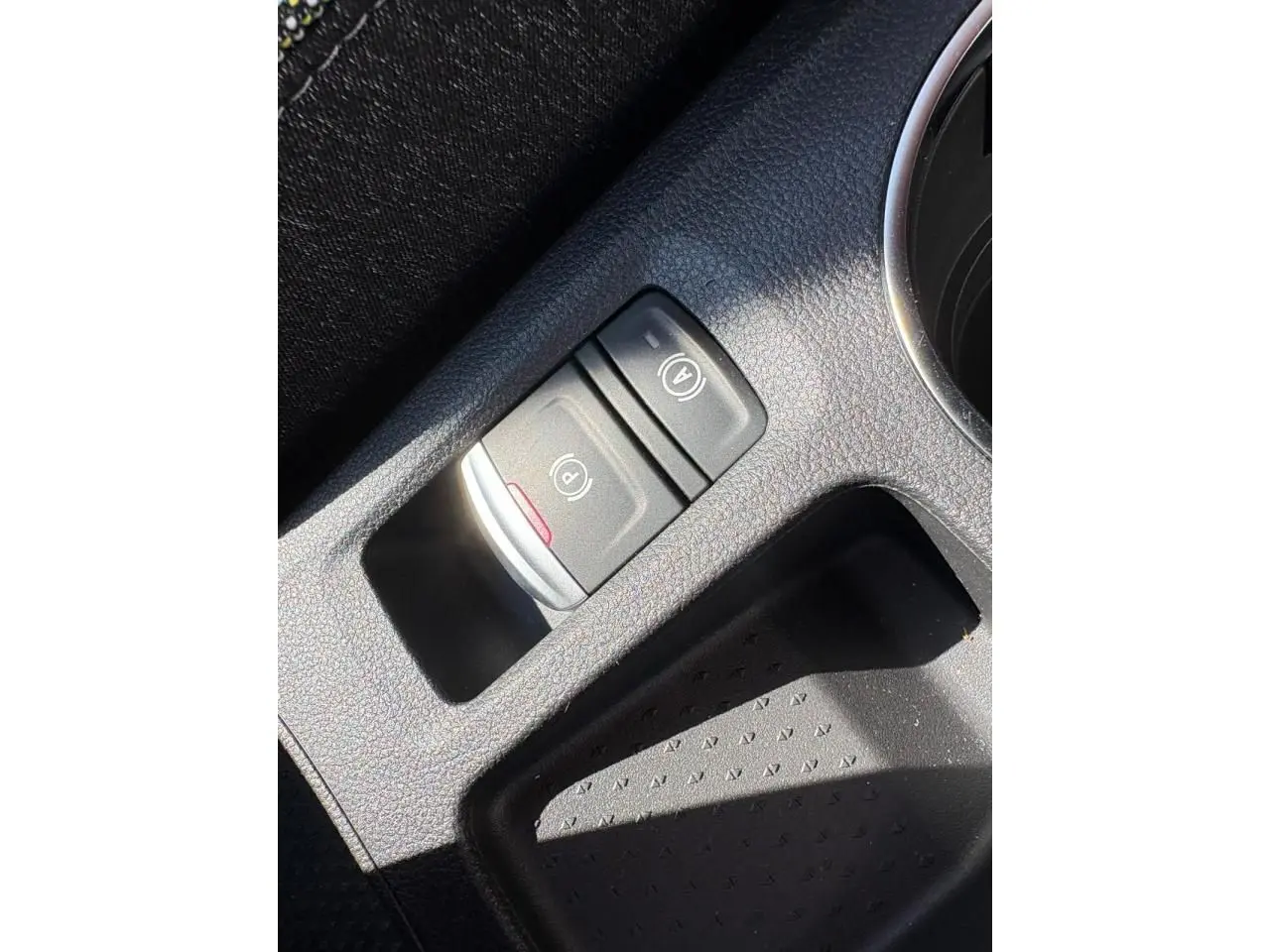 Gros plan sur la console centrale noire du Renault Symbioz 2025, montrant les commandes du frein de parking électrique et Auto-Hold.