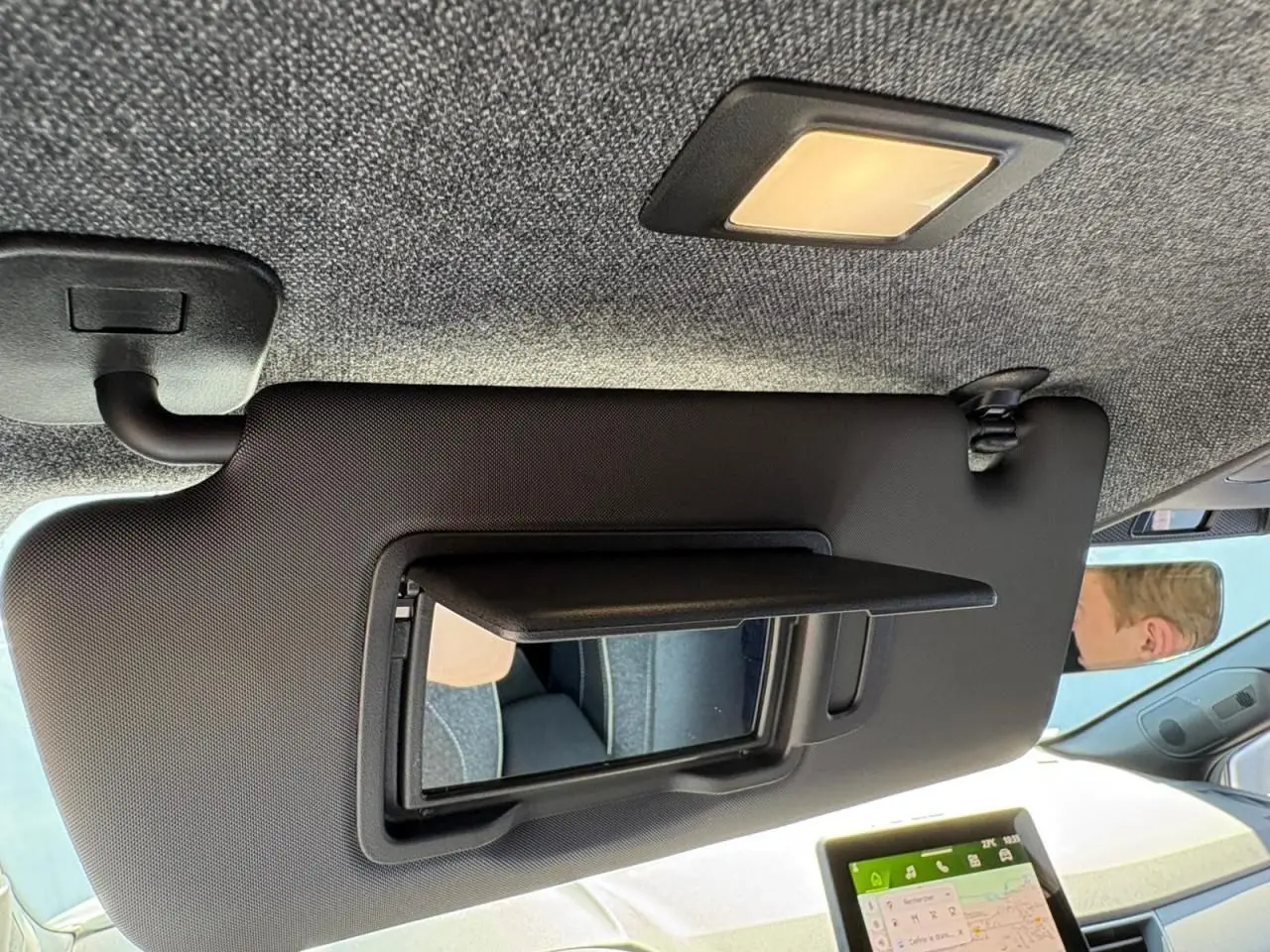 Miroir de courtoisie ouvert sur pare-soleil côté conducteur dans l’habitacle clair d’une Renault Symbioz blanc nacré.