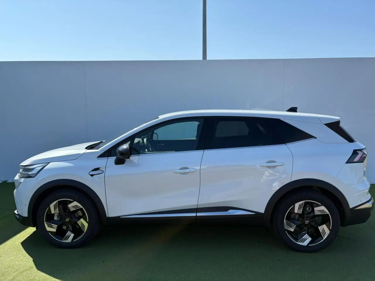 Profil côté gauche du Renault SYMBIOZ blanc nacré 2025 avec jantes 18 pouces Gravity et vitres surteintées.