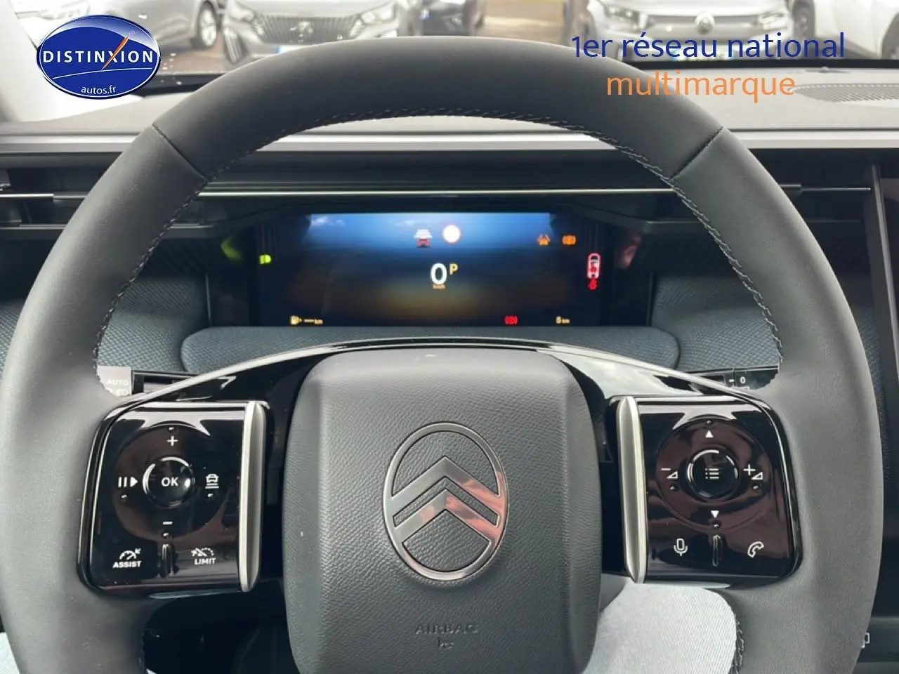 Vue rapprochée du volant multifonction noir du Citroën C5 Aircross 2026 avec tableau de bord numérique en arrière-plan.