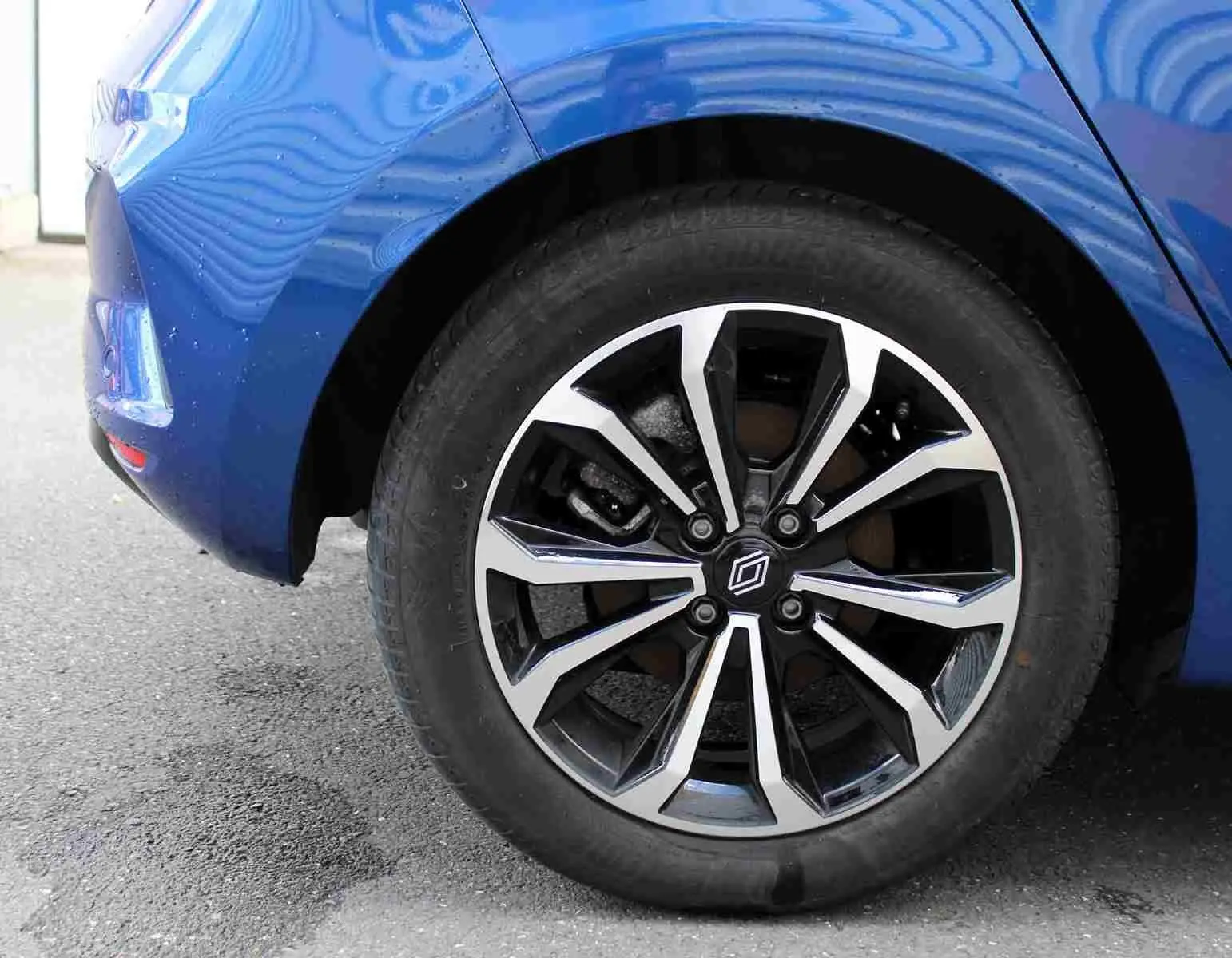 Gros plan sur la roue avant droite de la Renault Clio bleu iron metal avec jante alliage au design moderne.