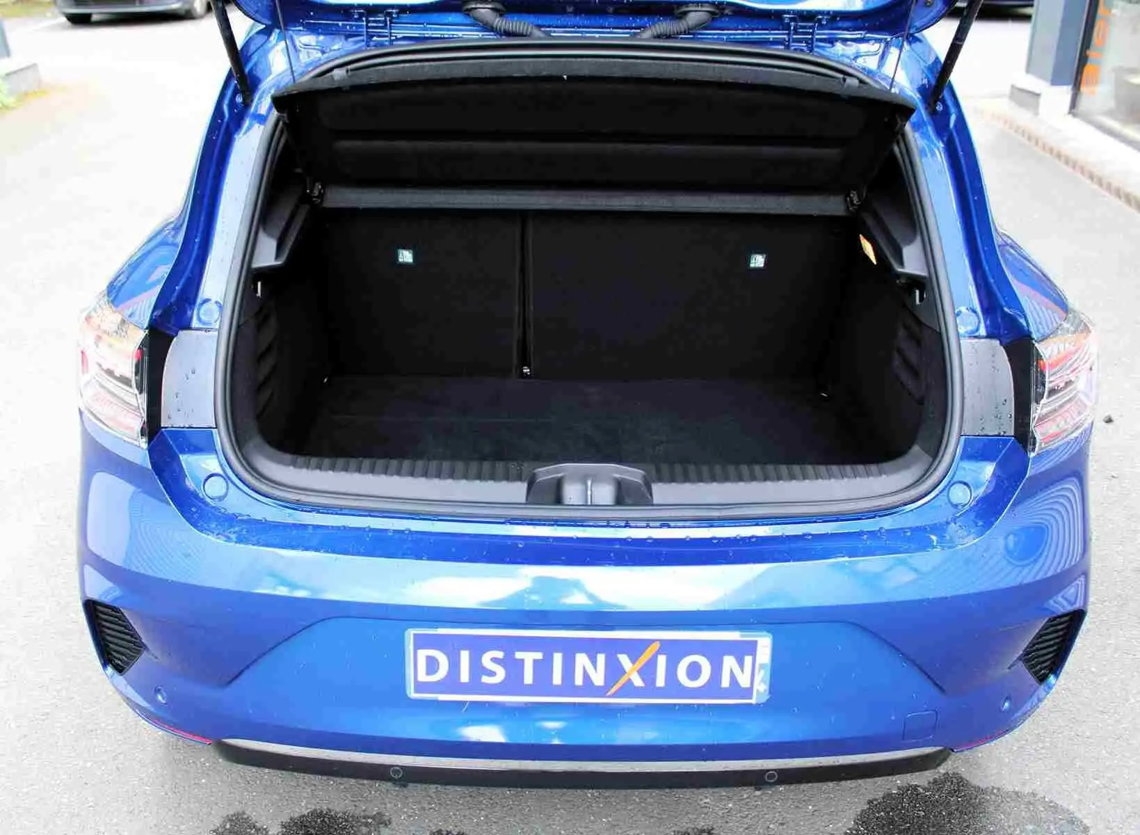 Gros plan sur la roue avant droite d'une Renault Clio bleu iron metal avec jante alliage bicolore moderne.